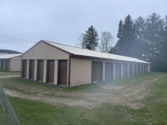 Row of self storage units with brown roll-up doors at Self Storage Solutions of Wellsville